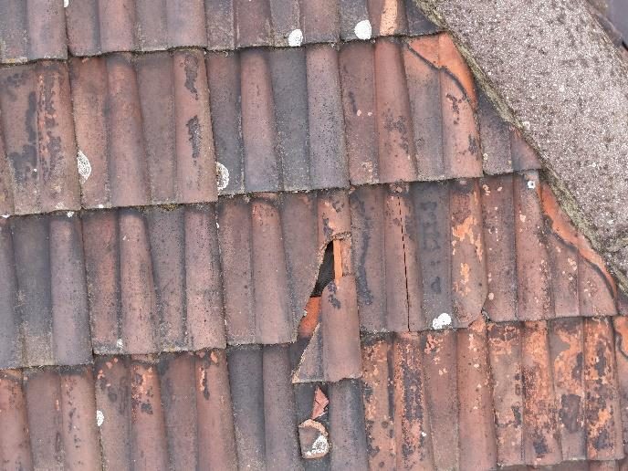 Broken clay roof tile exposing the underfelt on the north tower