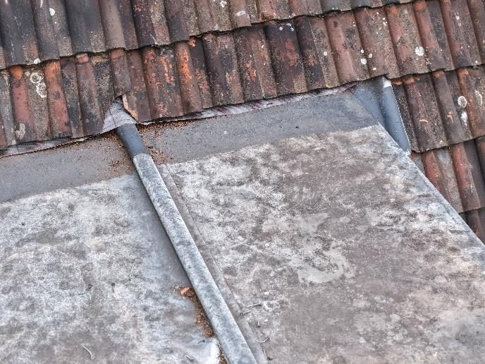 Sealant applied between clay tile laps above a lead dormer roof